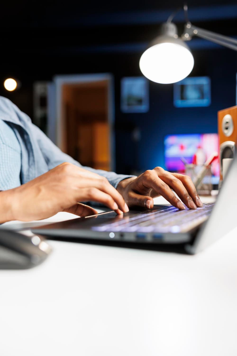 Analyst working at a laptop late in the evening, reviewing research on screen